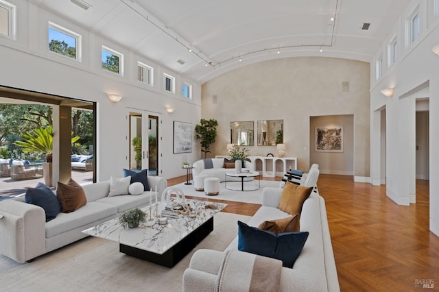 living room featuring high vaulted ceiling and light parquet flooring