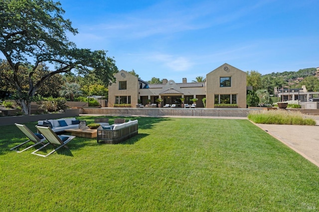 back of property with a yard and an outdoor living space