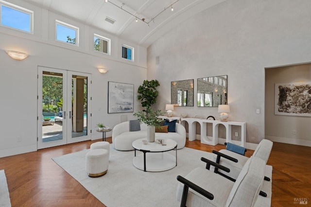 living room featuring a towering ceiling, parquet flooring, french doors, and plenty of natural light