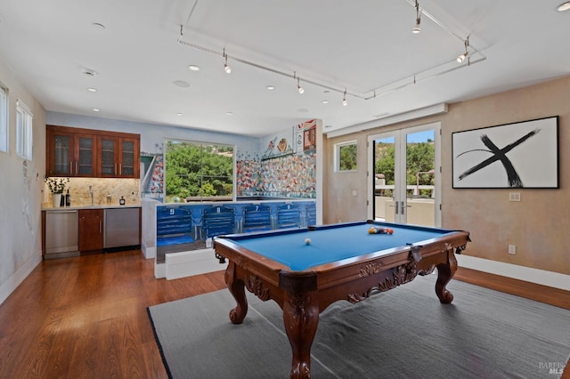 rec room with billiards, dark hardwood / wood-style flooring, track lighting, bar area, and french doors