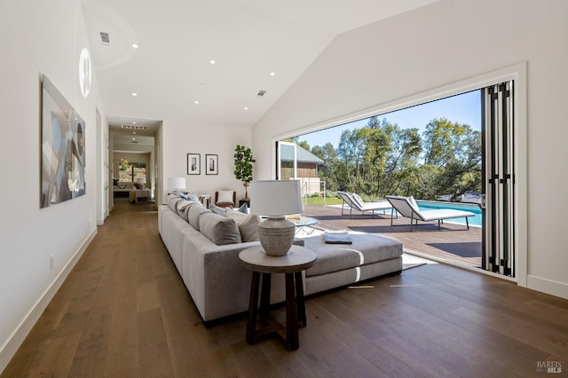 living room with plenty of natural light, dark hardwood / wood-style flooring, and high vaulted ceiling