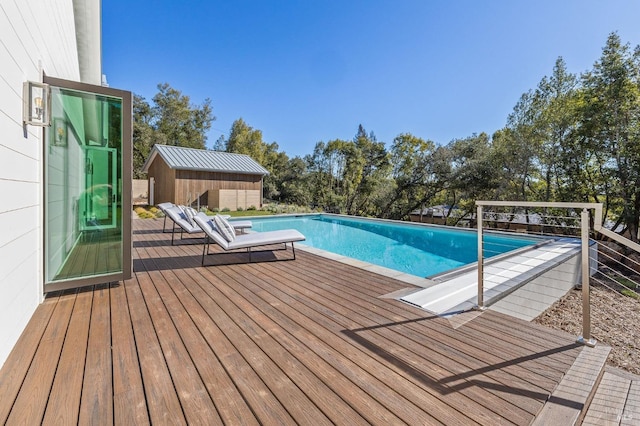 view of pool with an outbuilding and a deck