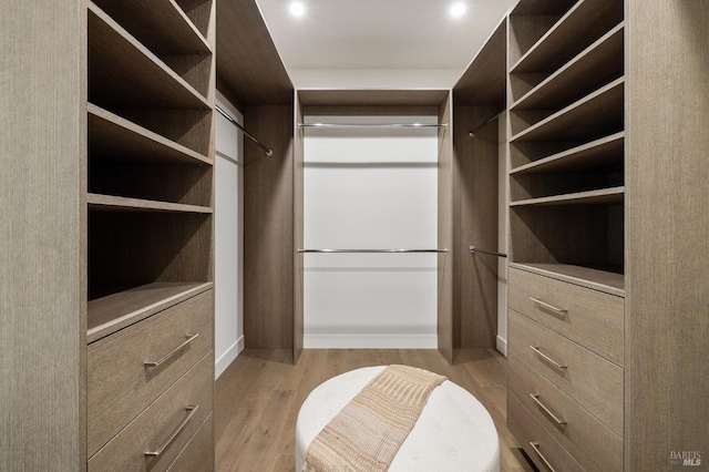 walk in closet with light hardwood / wood-style flooring