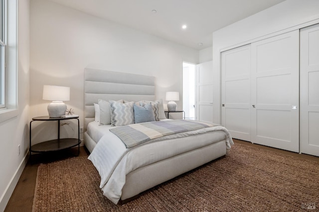 bedroom with dark wood-type flooring and a closet