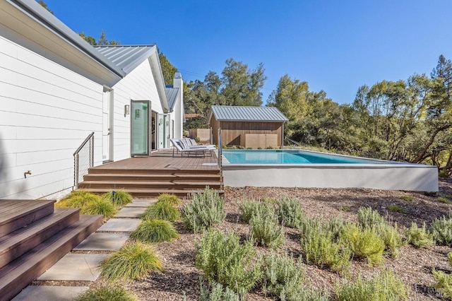 view of pool featuring a deck and a storage unit