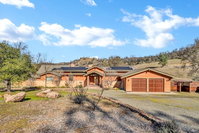 view of front of house featuring a garage and solar panels