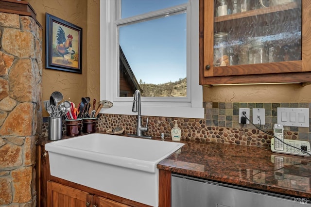 interior details with dishwashing machine, sink, and decorative backsplash