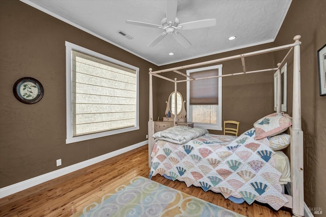 bedroom with hardwood / wood-style floors, crown molding, and ceiling fan