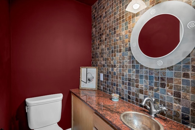 bathroom with tasteful backsplash, vanity, and toilet