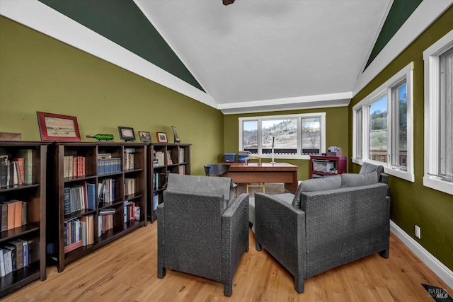 living area featuring lofted ceiling and light hardwood / wood-style flooring