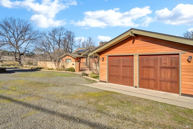 view of front of house with an outbuilding, a garage, and a front lawn