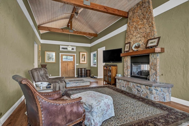 living room featuring wood ceiling, wood-type flooring, a stone fireplace, and beamed ceiling