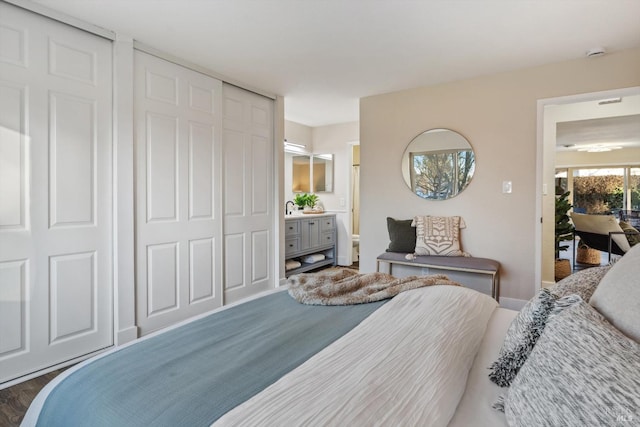 bedroom featuring sink, dark hardwood / wood-style floors, and ensuite bathroom