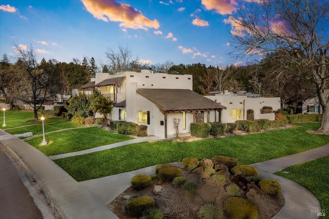 pueblo revival-style home featuring a yard