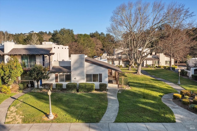 view of front of property with a balcony and a front lawn