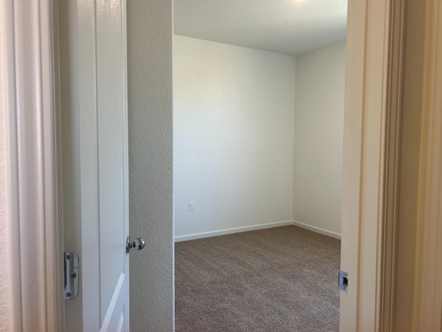 unfurnished room featuring carpet and baseboards