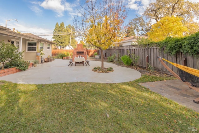 view of yard featuring an outdoor fireplace and a patio