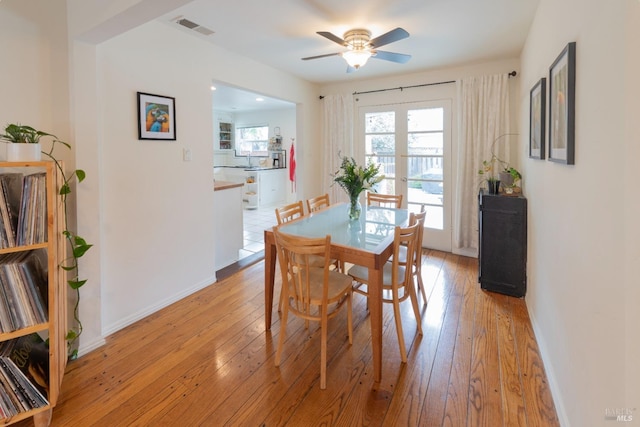 dining space featuring light hardwood / wood-style flooring, ceiling fan, and french doors