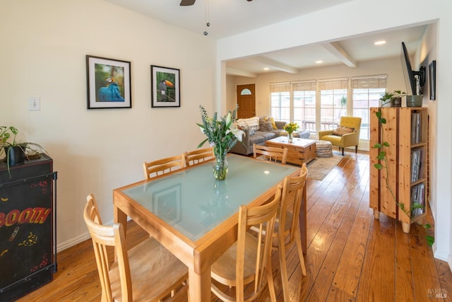 dining space featuring beam ceiling, light hardwood / wood-style floors, and ceiling fan