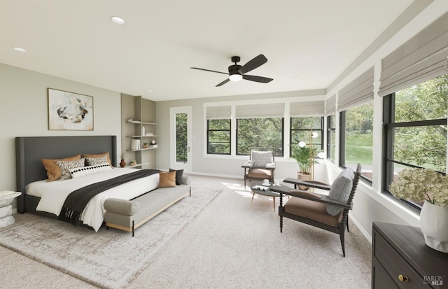 bedroom with ceiling fan, light colored carpet, and multiple windows