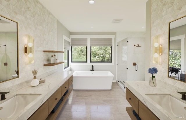 bathroom featuring vanity, separate shower and tub, and tile walls