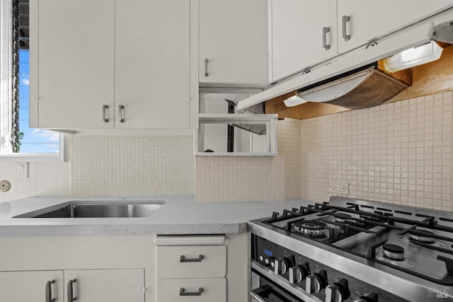 kitchen with gas stove, light countertops, decorative backsplash, and white cabinetry