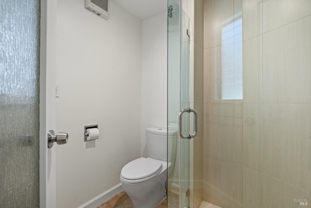 full bathroom featuring tile patterned flooring, a shower stall, toilet, and baseboards