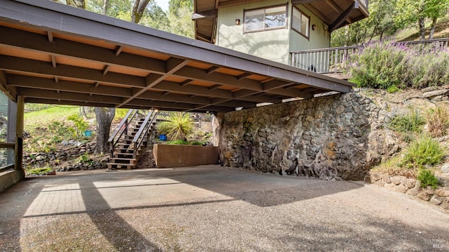 view of parking / parking lot with stairs and a carport