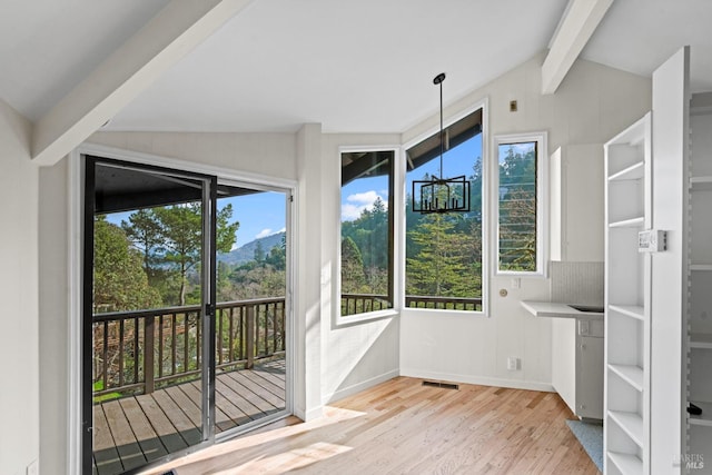 unfurnished sunroom with a wealth of natural light, visible vents, and vaulted ceiling with beams