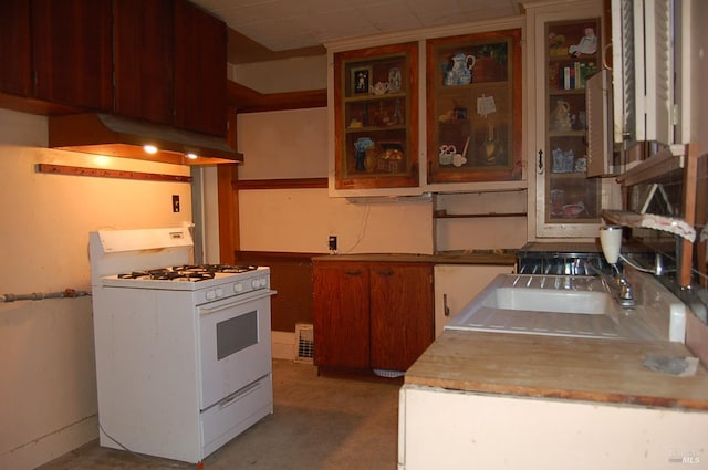 kitchen with custom exhaust hood and white gas stove