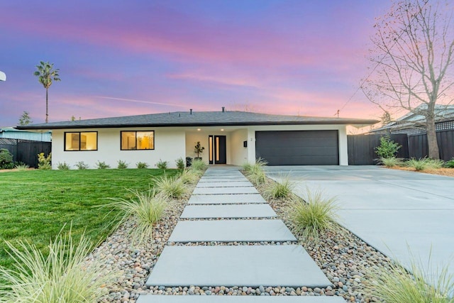 ranch-style house with a garage and a lawn