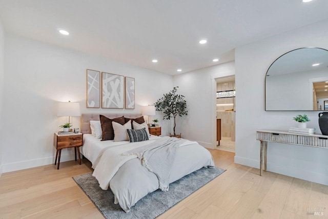 bedroom featuring ensuite bath and light hardwood / wood-style flooring