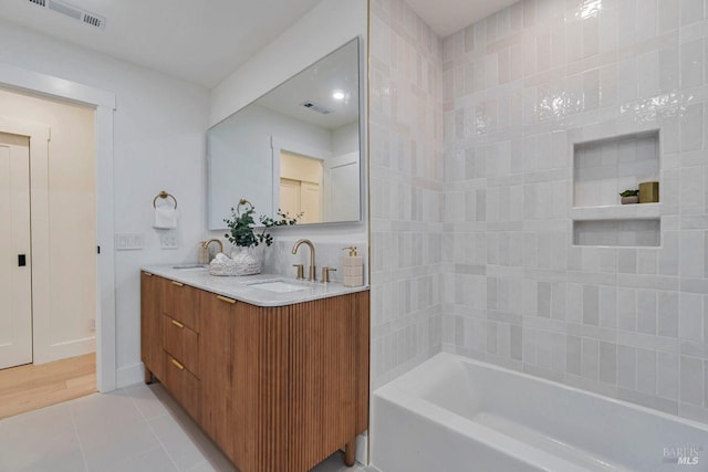 bathroom with shower / tub combination, vanity, and tile patterned flooring