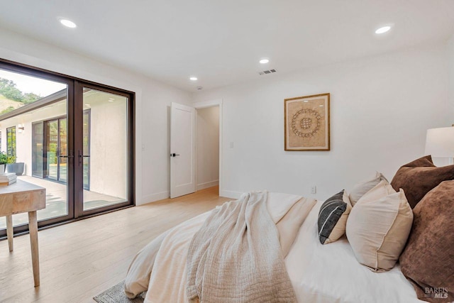 bedroom with access to exterior, light hardwood / wood-style flooring, and french doors