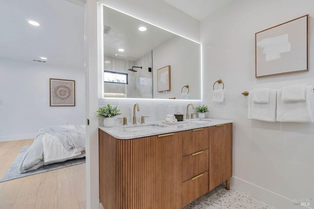 bathroom with vanity, hardwood / wood-style flooring, and tiled shower