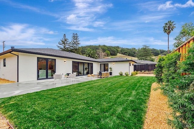 back of property featuring a patio, outdoor lounge area, a yard, and french doors