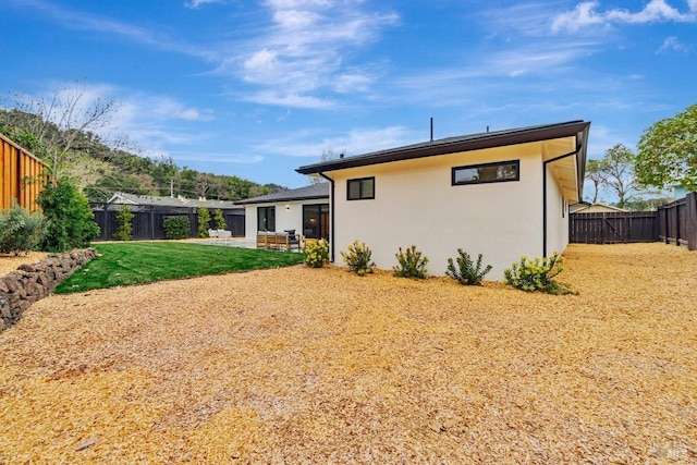 rear view of property featuring a yard and a patio area