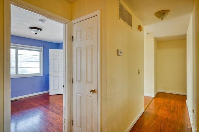 hallway featuring hardwood / wood-style floors and a textured ceiling