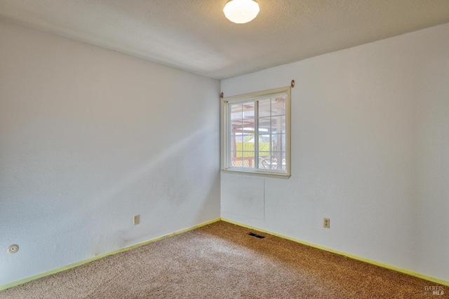 empty room featuring a textured ceiling and carpet flooring