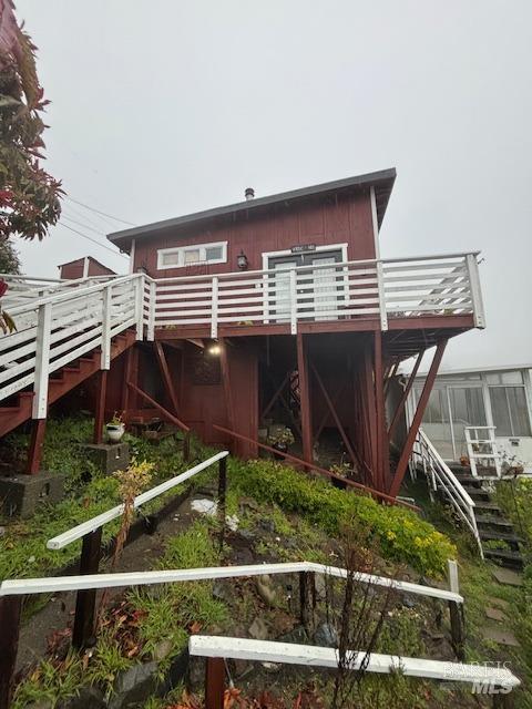 rear view of house featuring a wooden deck