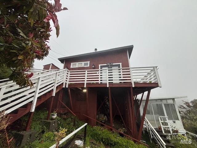 rear view of property featuring a wooden deck