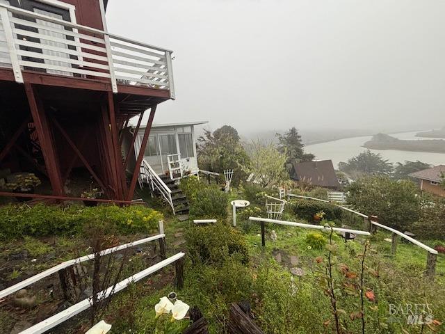 view of yard with a water view and a sunroom