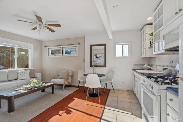 interior space with ceiling fan, sink, and beam ceiling