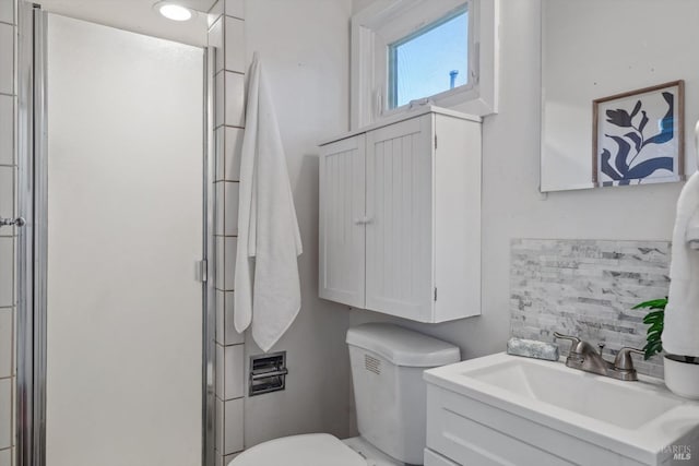 bathroom featuring vanity, decorative backsplash, a shower with shower door, and toilet