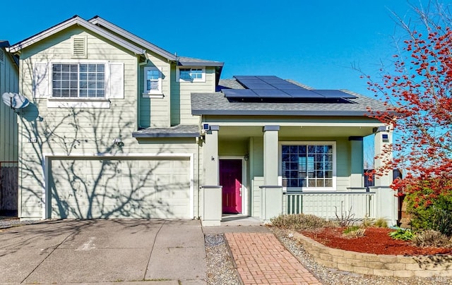 view of front facade with a garage, a porch, and solar panels