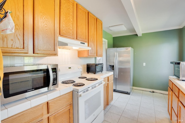 kitchen featuring beamed ceiling, appliances with stainless steel finishes, tile countertops, and light tile patterned floors