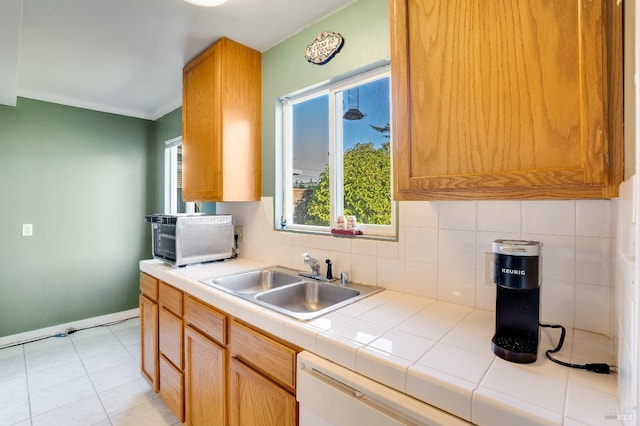 kitchen featuring sink, tile countertops, light tile patterned floors, dishwasher, and decorative backsplash