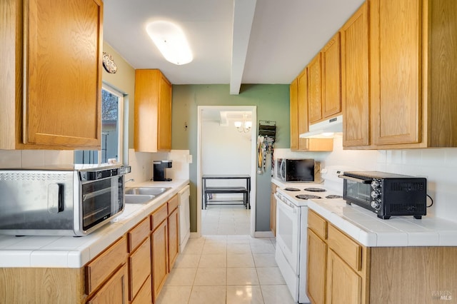 kitchen with light tile patterned floors, white appliances, tasteful backsplash, tile counters, and beamed ceiling