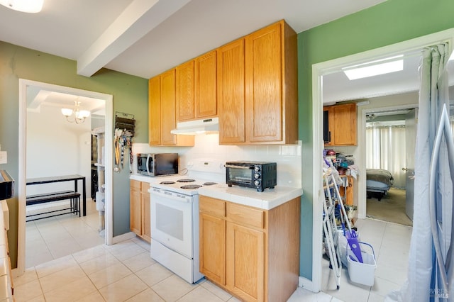 kitchen with an inviting chandelier, light tile patterned floors, appliances with stainless steel finishes, beam ceiling, and decorative backsplash