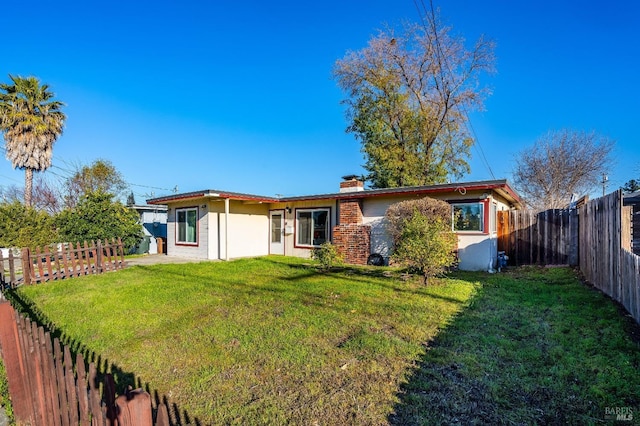 rear view of house with a yard